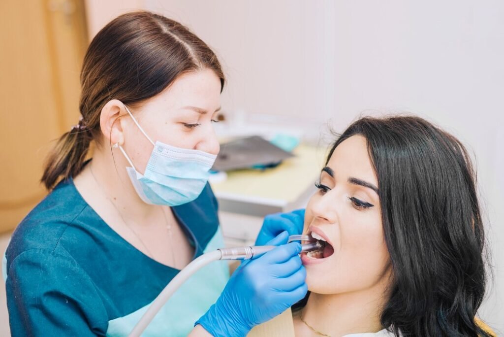 Dentist performing dental cleaning and oral examination on a patient