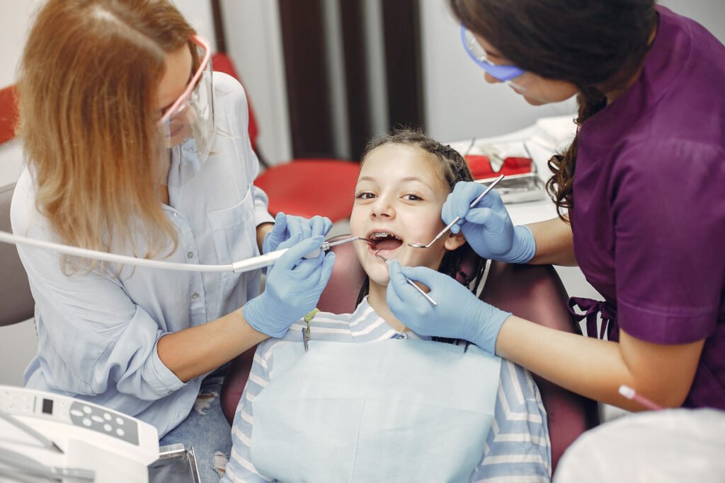 Child receiving dental treatment from pediatric dentist in modern clinic