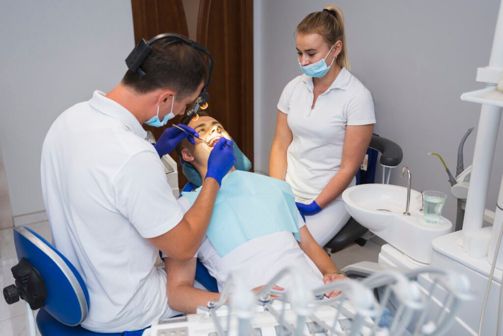 Dentist performing dental treatment with assistant in modern dental clinic