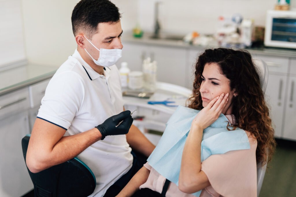 Dentist examining patient with jaw pain during dental consultation