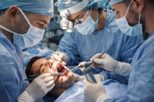 Oral and maxillofacial surgeons performing jaw fracture surgery on a patient during emergency facial trauma treatment.